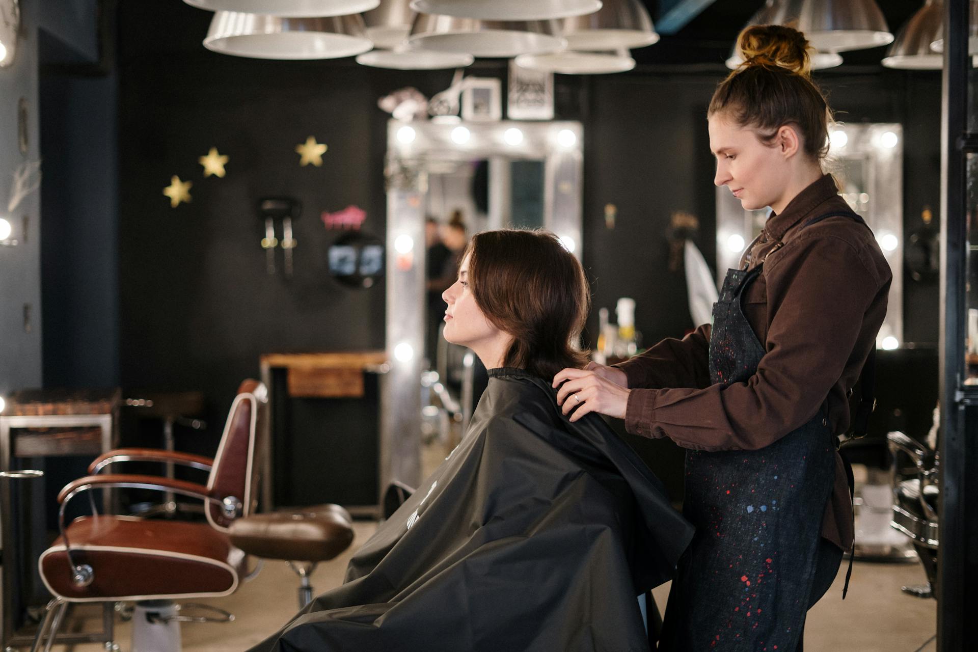 Hairstylist trimming a client's hair with focused attention in a modern salon